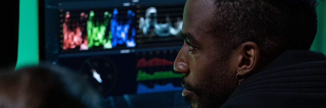 An analyst reviewing waveform and signal data on a monitor in a darkened room.