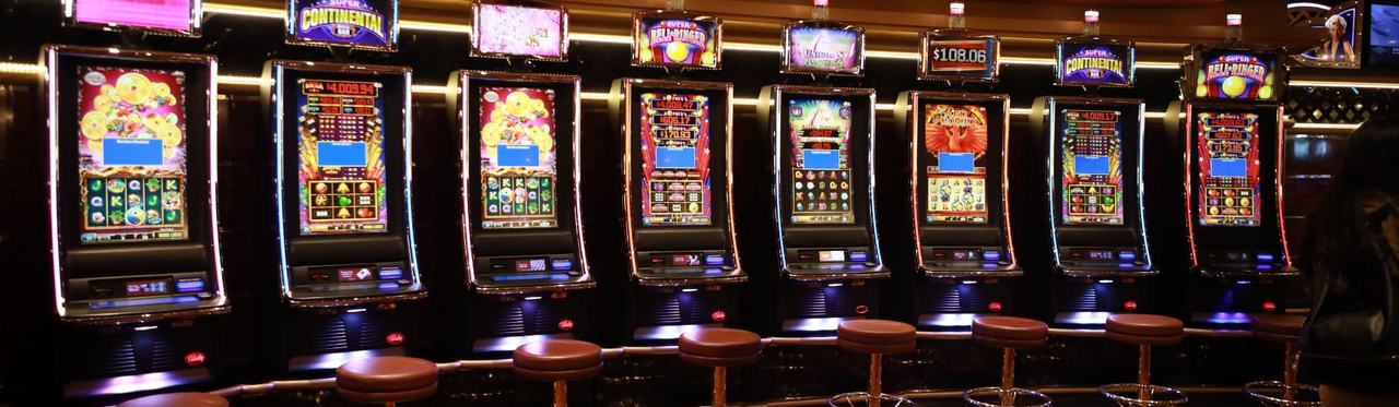 A row of electronic gaming machines on a land-based venue floor.